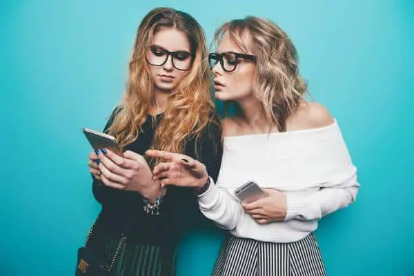 2 girls holding phones in hands